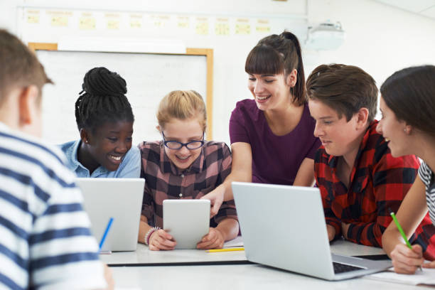 teenage students with teacher in it class